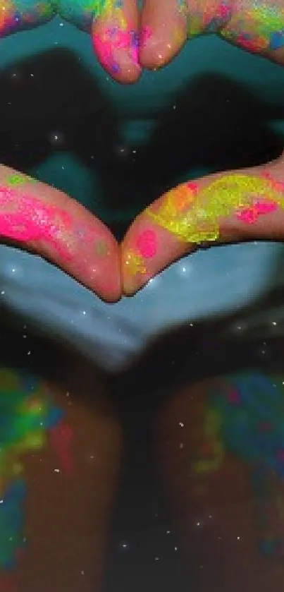 Hands forming a heart with neon paint on a dark background.