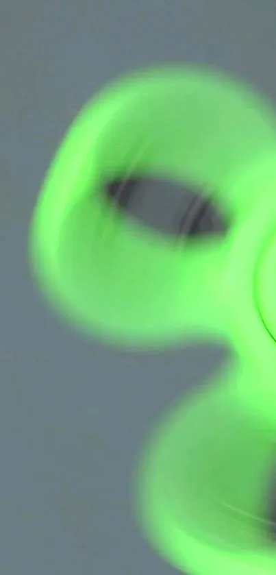 Neon green fidget spinner in motion on a phone wallpaper.