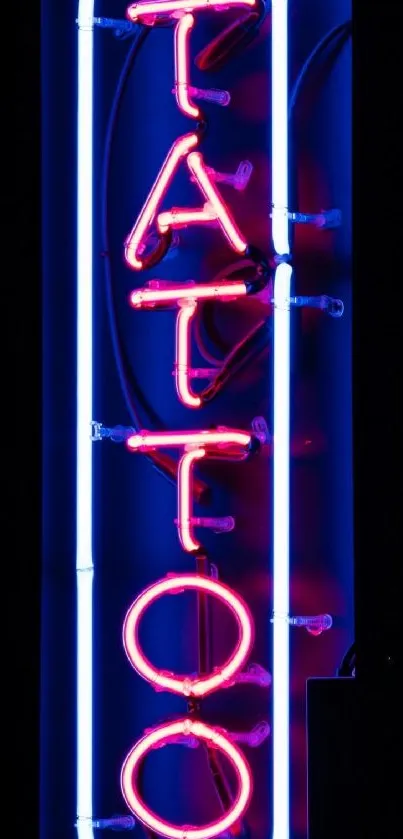 Neon 'Tattoo' sign glowing in pink and blue hues.