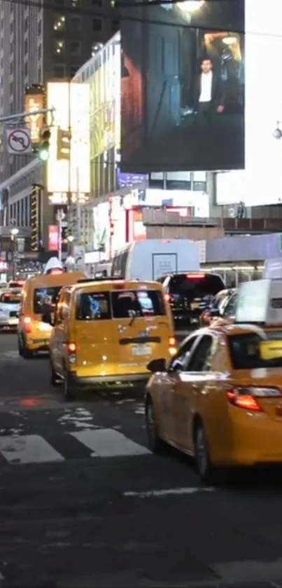 Bustling New York City street with yellow taxis under city lights at night.