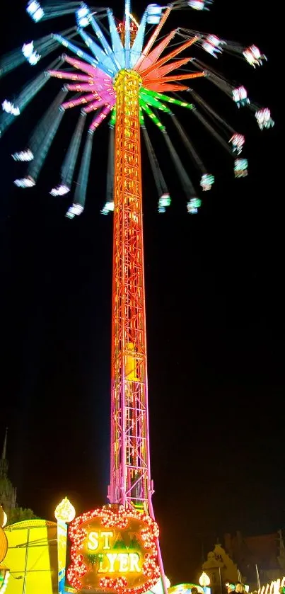A vibrant amusement ride lights up the night with colorful motion and excitement.