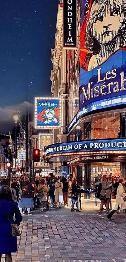 City street with Les Misérables theater poster at night.