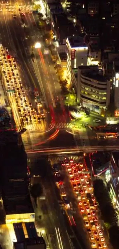 Aerial view of a vibrant city intersection at night with illuminated streets.