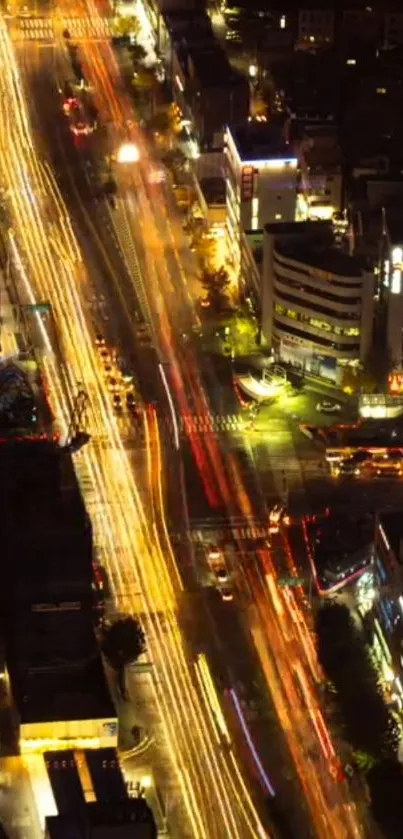 Aerial view of a vibrant city street lit up at night, featuring bustling traffic.