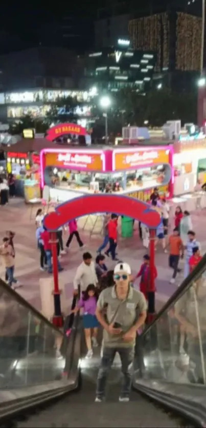 Escalator view overlooking a lively night market.