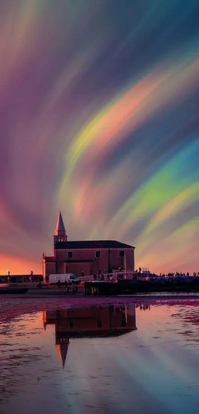 Colorful aurora over church with vibrant water reflection.