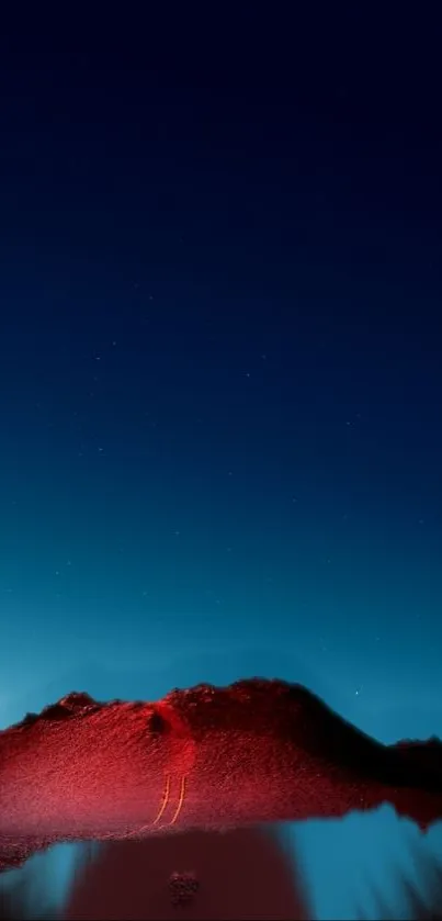 Red mountain under a dark blue starry night sky.