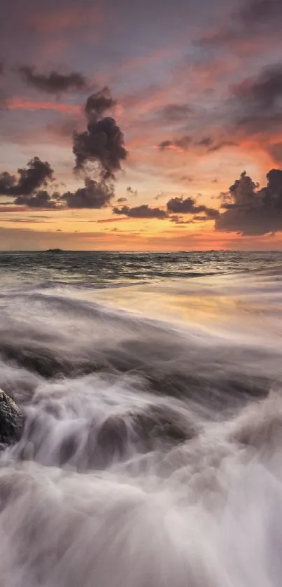 Sunset over ocean with waves crashing on rocks.