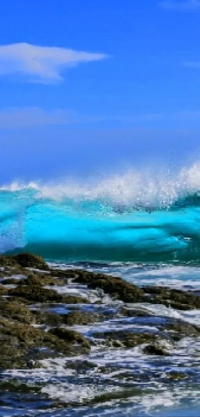 A vibrant ocean wave crashing on rocks under a clear blue sky.