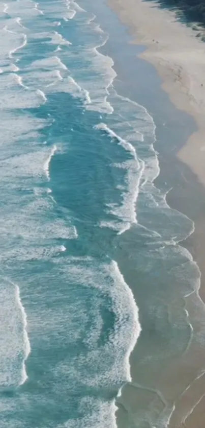 Aerial view of vibrant ocean waves and sandy beach.