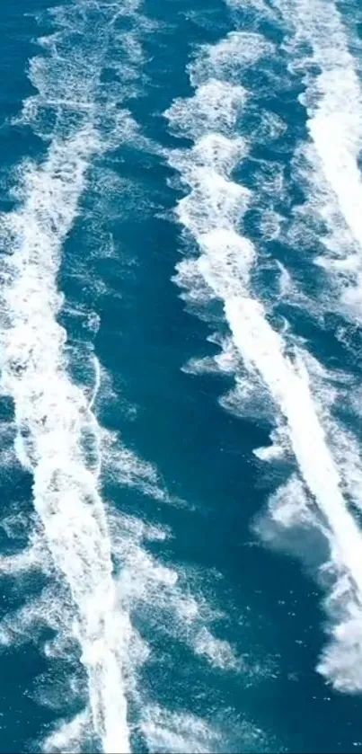 Aerial view of dynamic white ocean wakes on deep blue water.