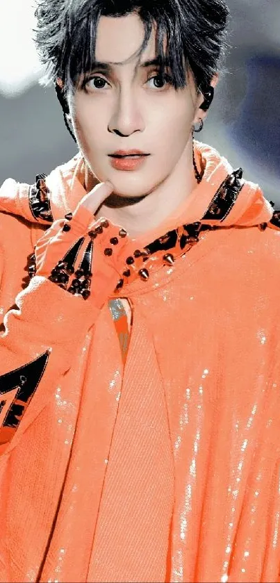 Person in vibrant orange hoodie with detailed patterns.