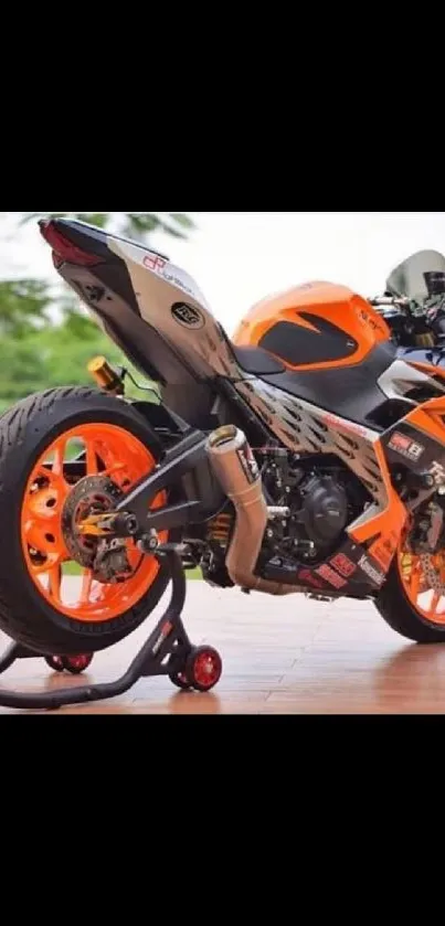 Vibrant orange motorcycle on a stand outdoors.