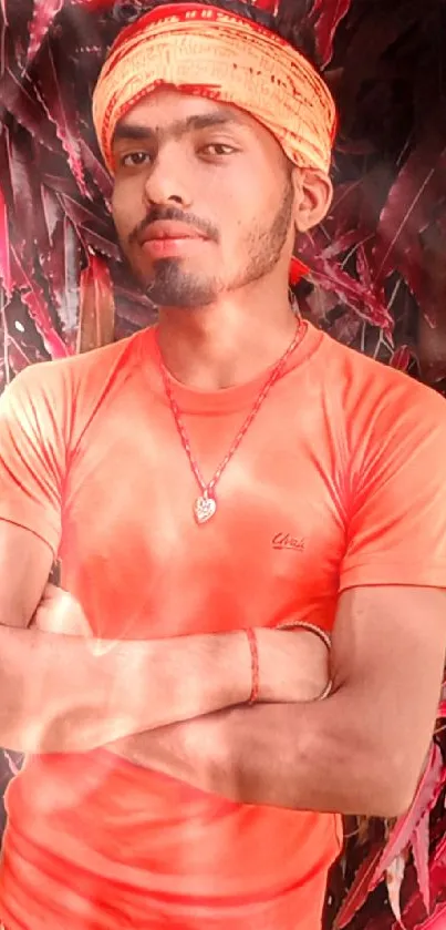 Person in vibrant orange attire with red leaves background.