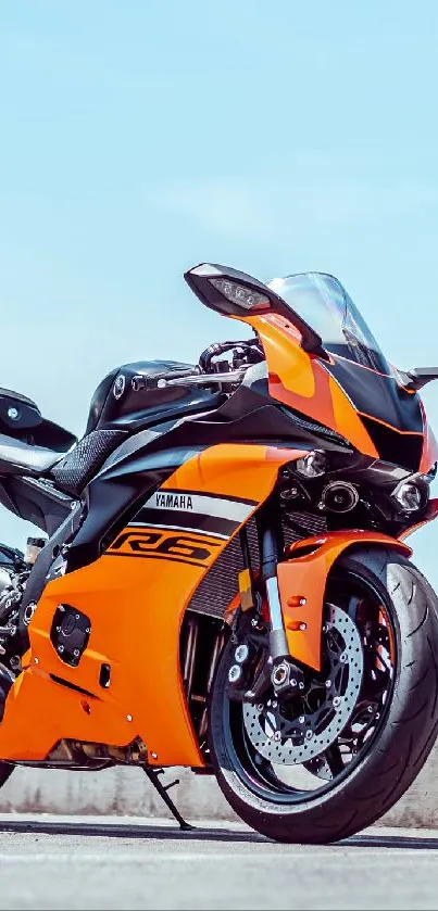 Orange sports bike with sleek design on a clear day, perfect mobile wallpaper.