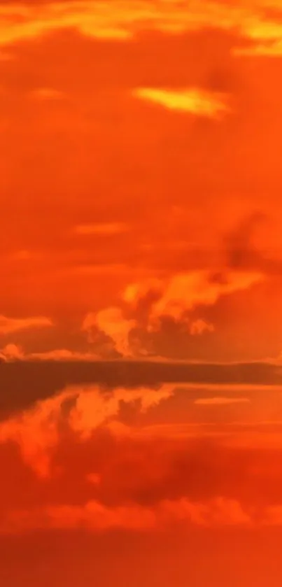 Vibrant orange sunset with glowing clouds and sun.