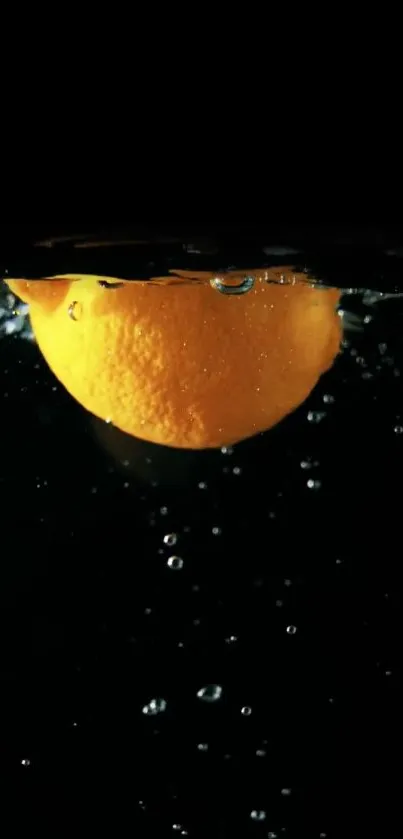 Orange fruit submerged underwater with bubbles in a dark background.