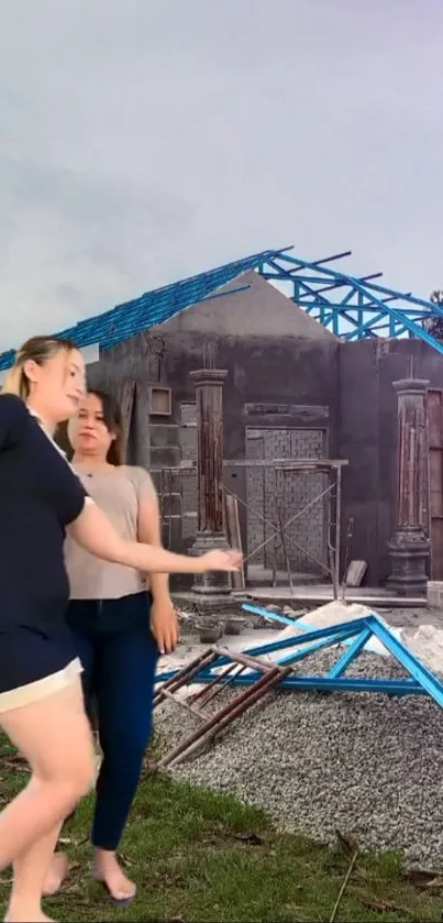 Two women dancing by a gray and blue construction site.