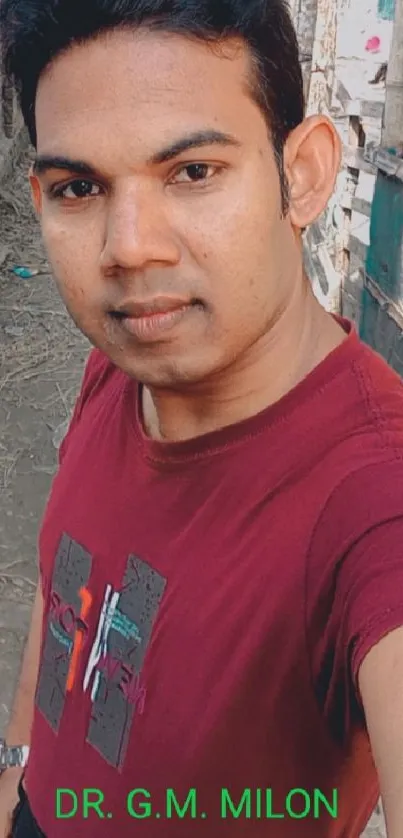 Portrait in burgundy shirt outdoors.