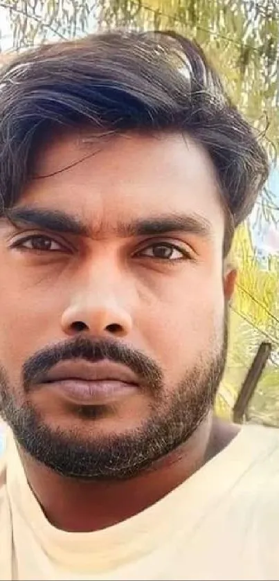 Close-up portrait of a man outdoors with natural background.