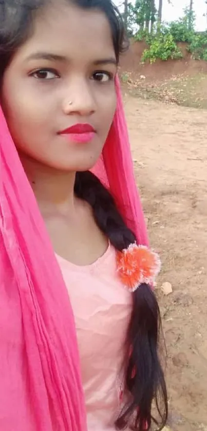 Outdoor portrait of a woman in a pink shawl against a natural background.