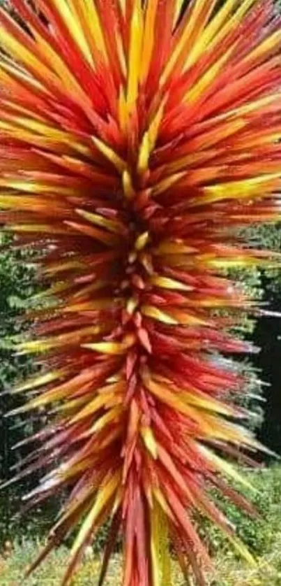 Colorful sculpture with red and yellow spikes in an outdoor setting.