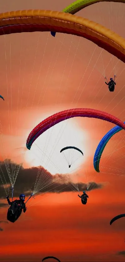 Colorful paraglider silhouettes against an orange sunset sky.