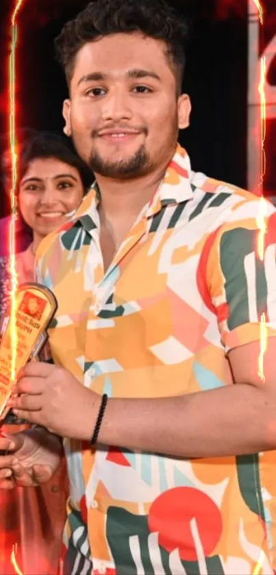 Person in a vibrant, colorful patterned shirt holding a trophy.