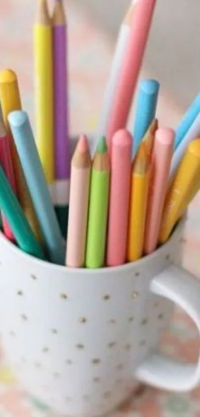 A white mug filled with colorful pencils on a patterned background.