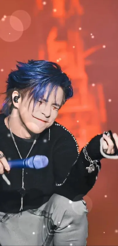 Performer with blue hair on stage in a vibrant setting.