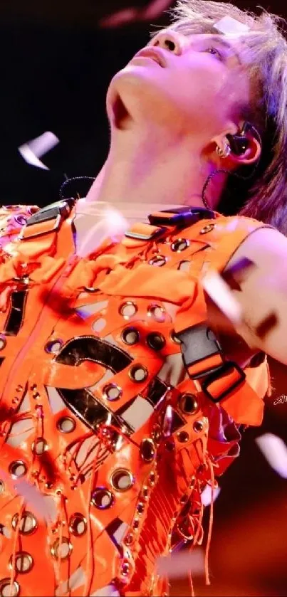 Performer in studded orange vest with confetti.