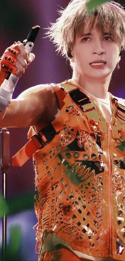 Vibrant performer in orange attire on stage, dynamic expression.