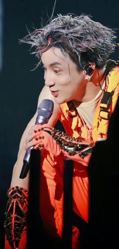 Performer in neon orange costume during a live concert.