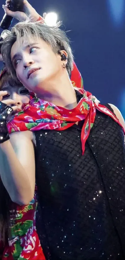 Vibrant performer with colorful scarf on stage during live concert.