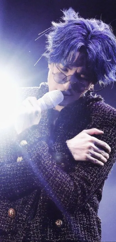 Performer with blue hair on stage holding a microphone.