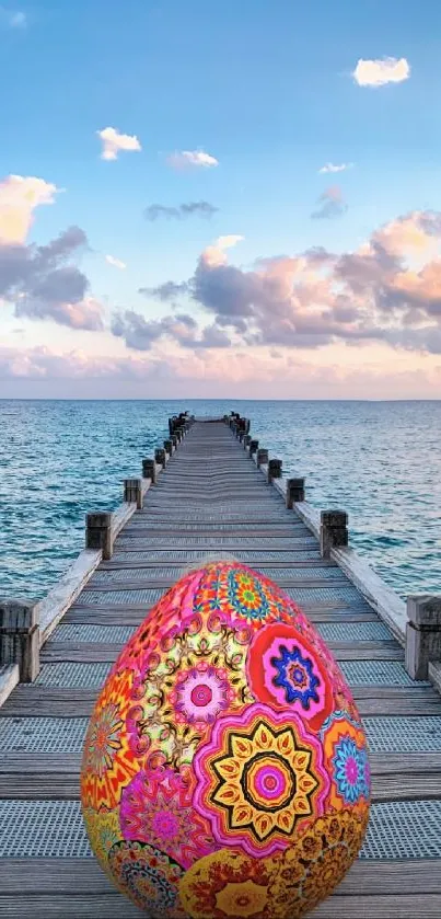 Vibrant decorative egg on a pier with ocean view.