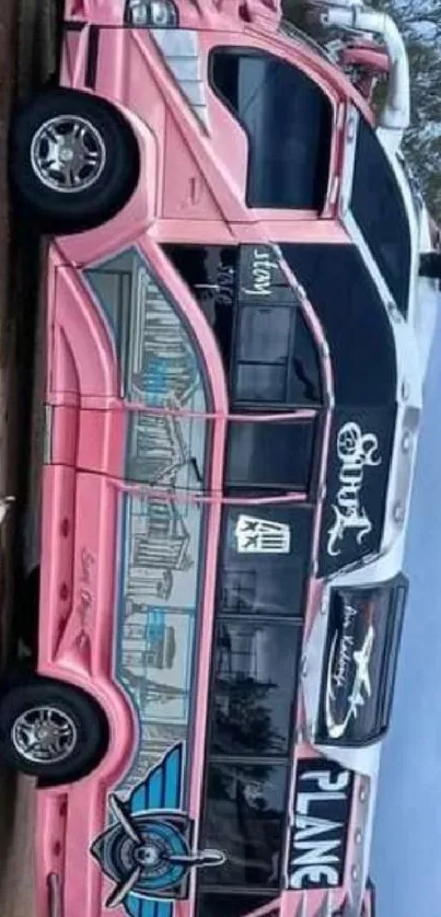 Vibrant pink bus with artistic design in urban setting.