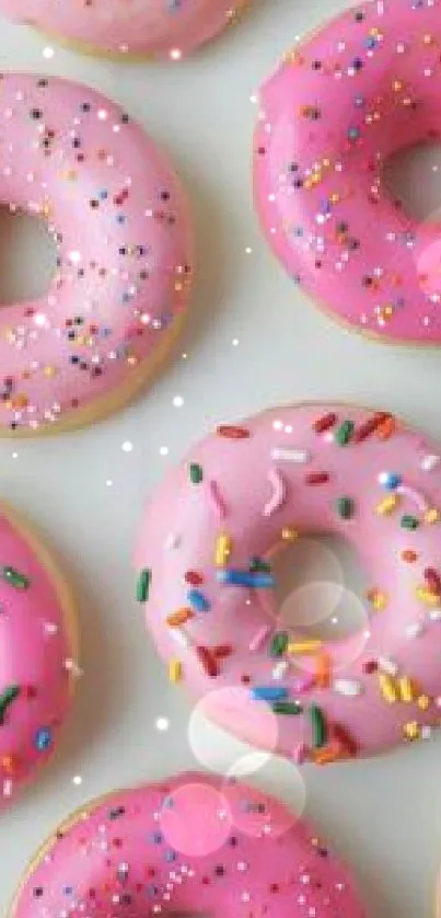 Vibrant pink donuts with colorful sprinkles, creating a playful wallpaper.