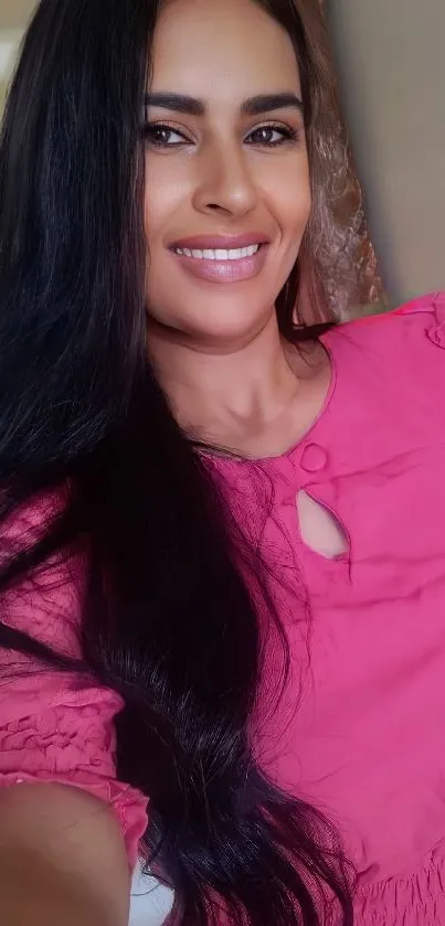 Person in vibrant pink outfit with long hair, posing elegantly.