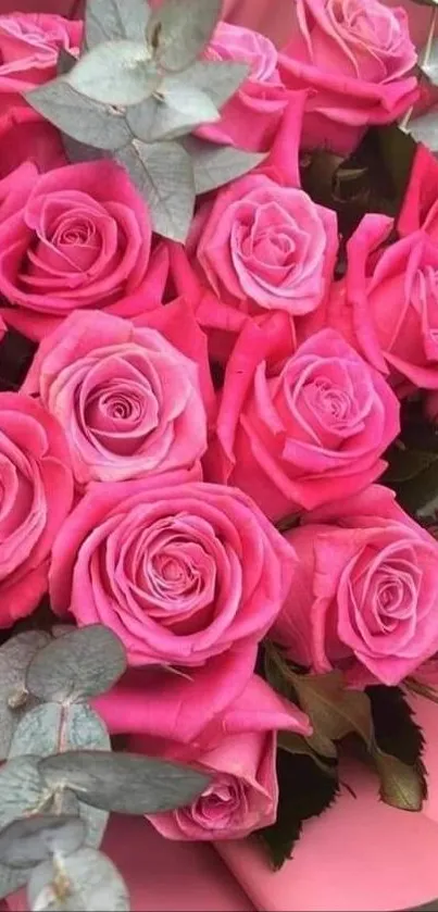 Close-up of a vibrant pink rose bouquet with lush greenery.