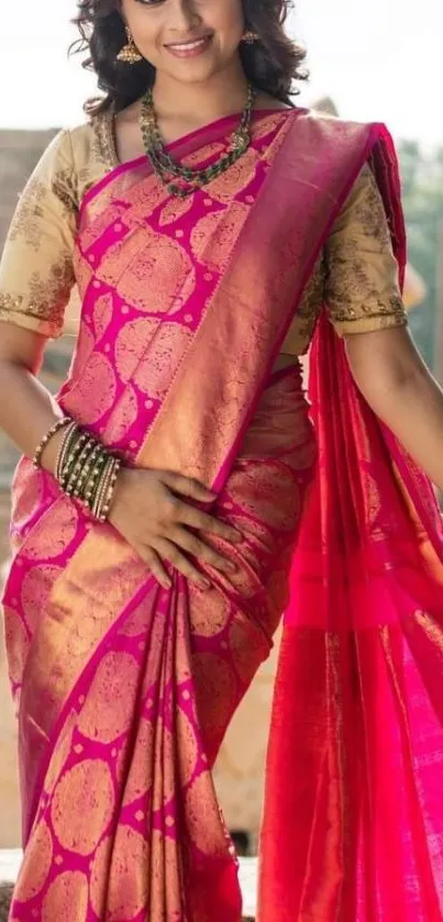 Elegant woman in vibrant pink sari surrounded by historic stone architecture.