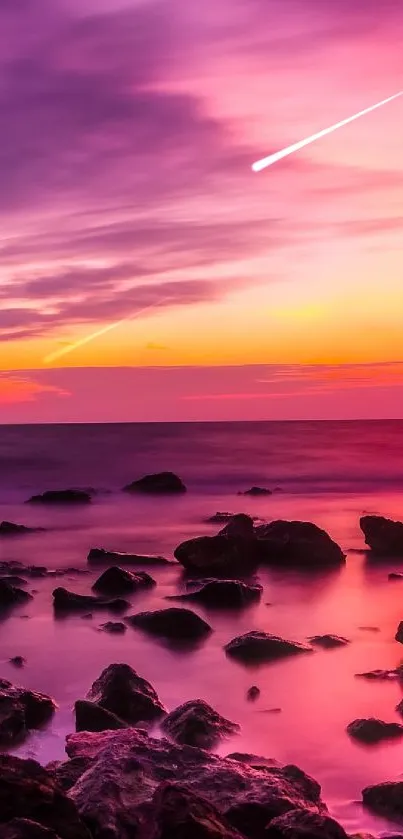 Beautiful pink sunset over rocky shore with purple clouds.