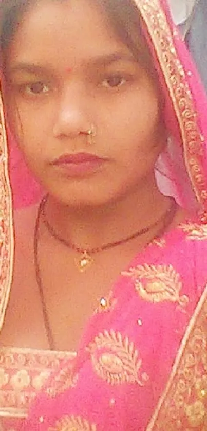 Mobile wallpaper of a woman in vibrant pink traditional attire.