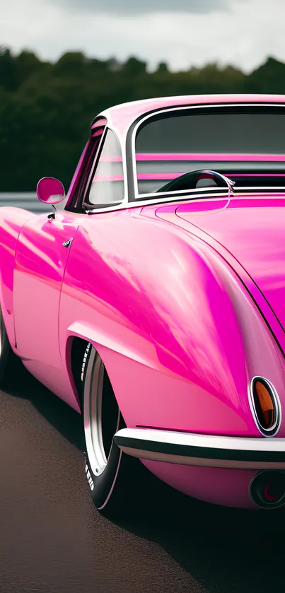 Pink vintage car with sleek design on road, perfect for mobile wallpaper.