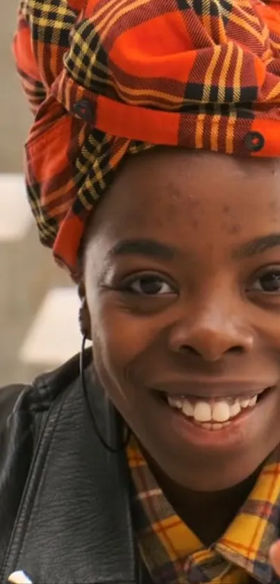 Vibrant plaid headwrap portrait of a smiling woman in warm colors.