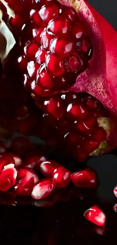 Close-up of vibrant pomegranate with rich red seeds on black background.