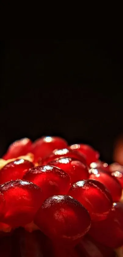 Close-up of vibrant red pomegranate seeds against a dark background.