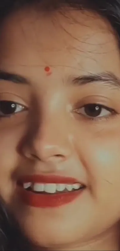 Close-up portrait of a smiling woman with dark hair.