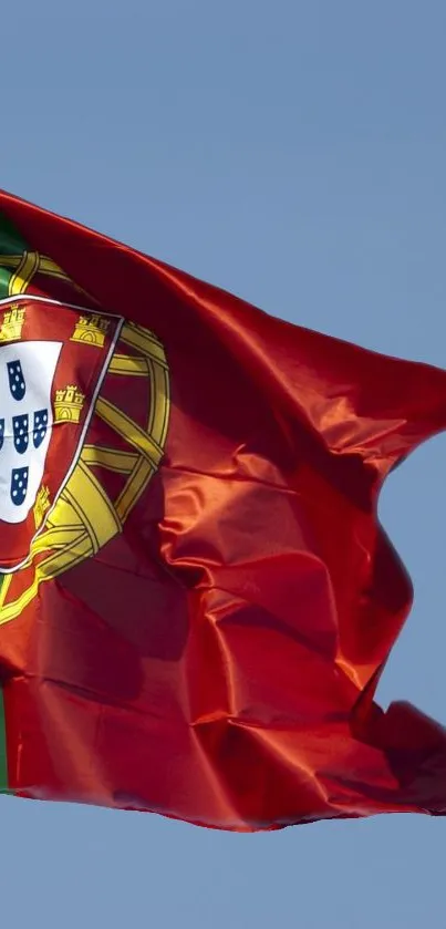 Portuguese flag waving against blue sky.