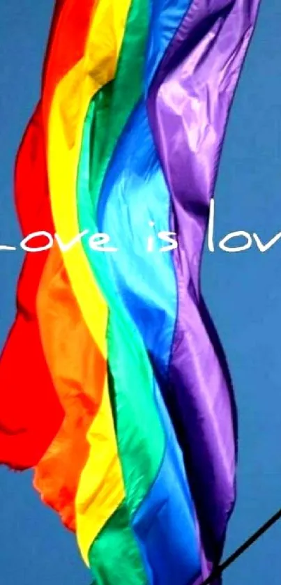 Vibrant rainbow flag on a blue sky background with 'Love is Love' text.